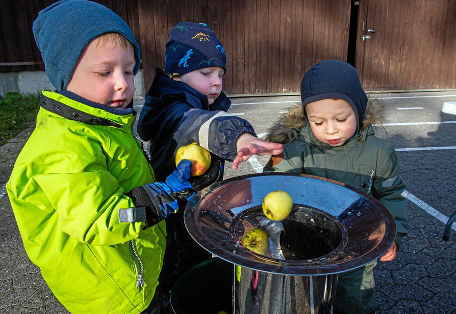 Tre børn laver æblemost